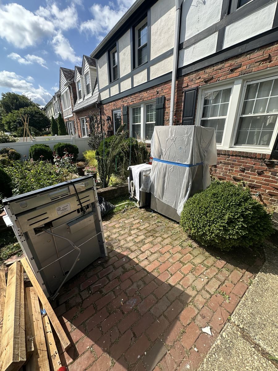Before — dishwasher and wrapped appliance staged outside Arlington townhouse