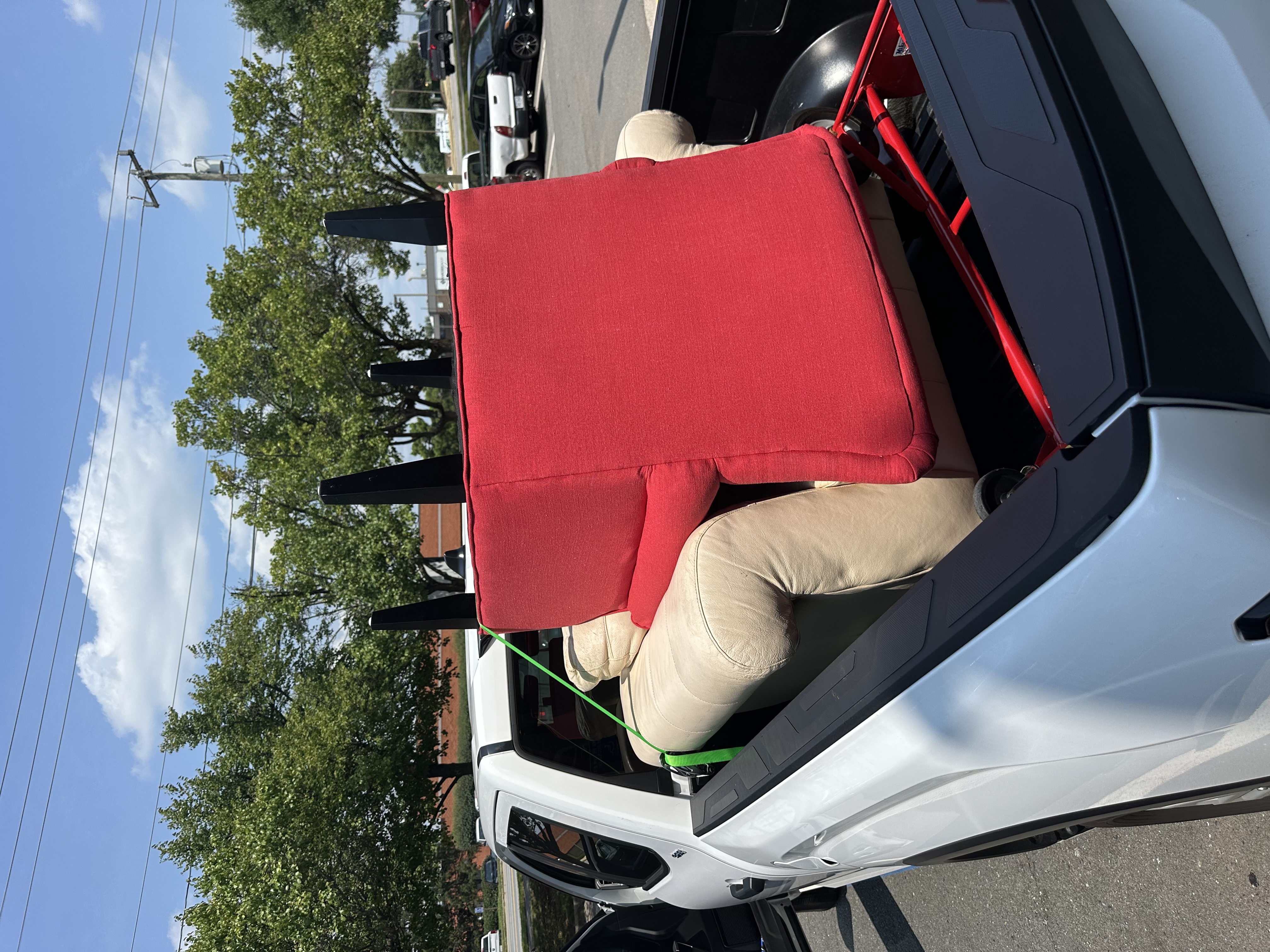 Red armchair and cream leather chair strapped down in truck bed — Chantilly VA