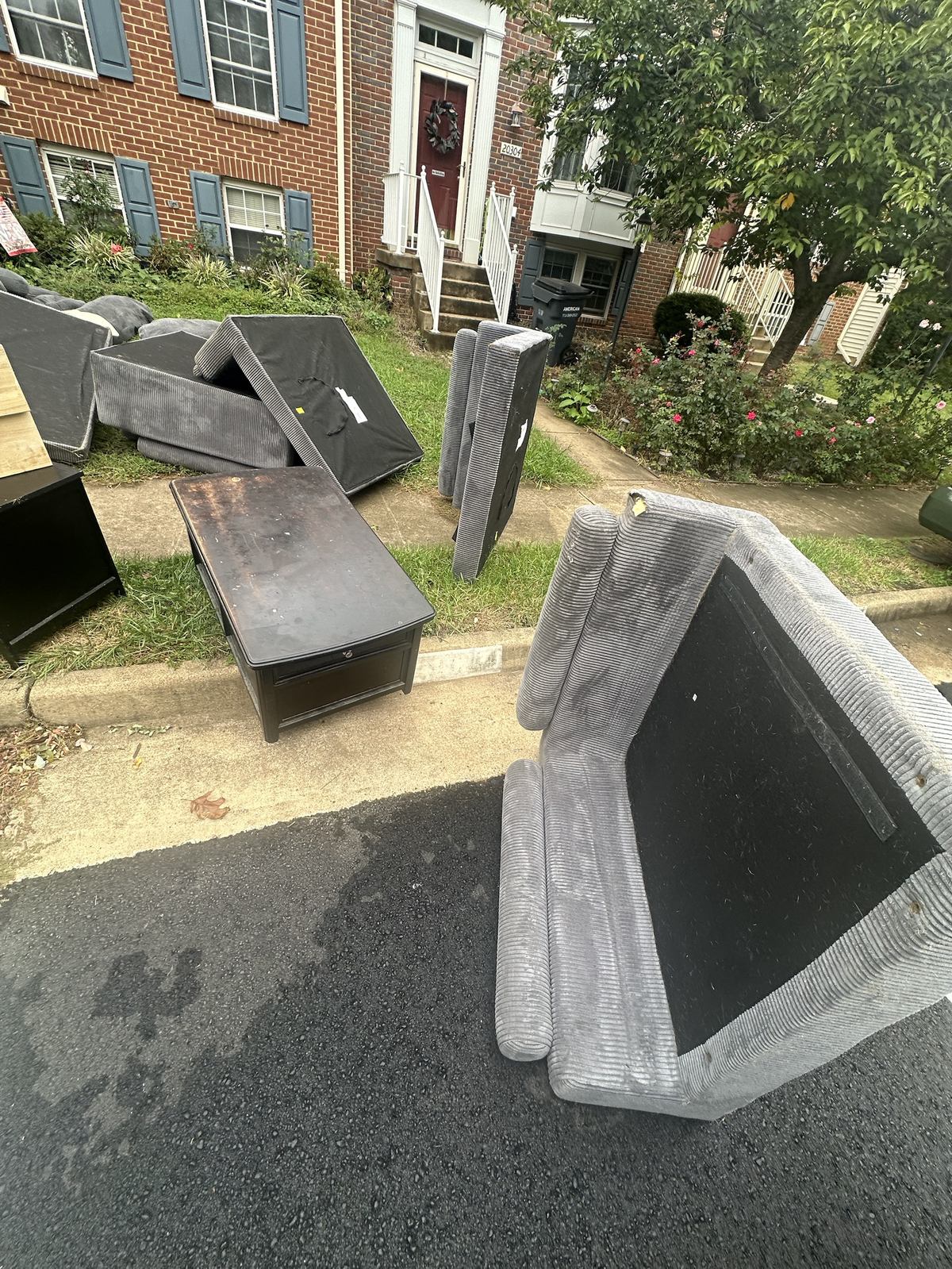 Sectional sofa pieces and coffee table before furniture removal — Sterling, VA