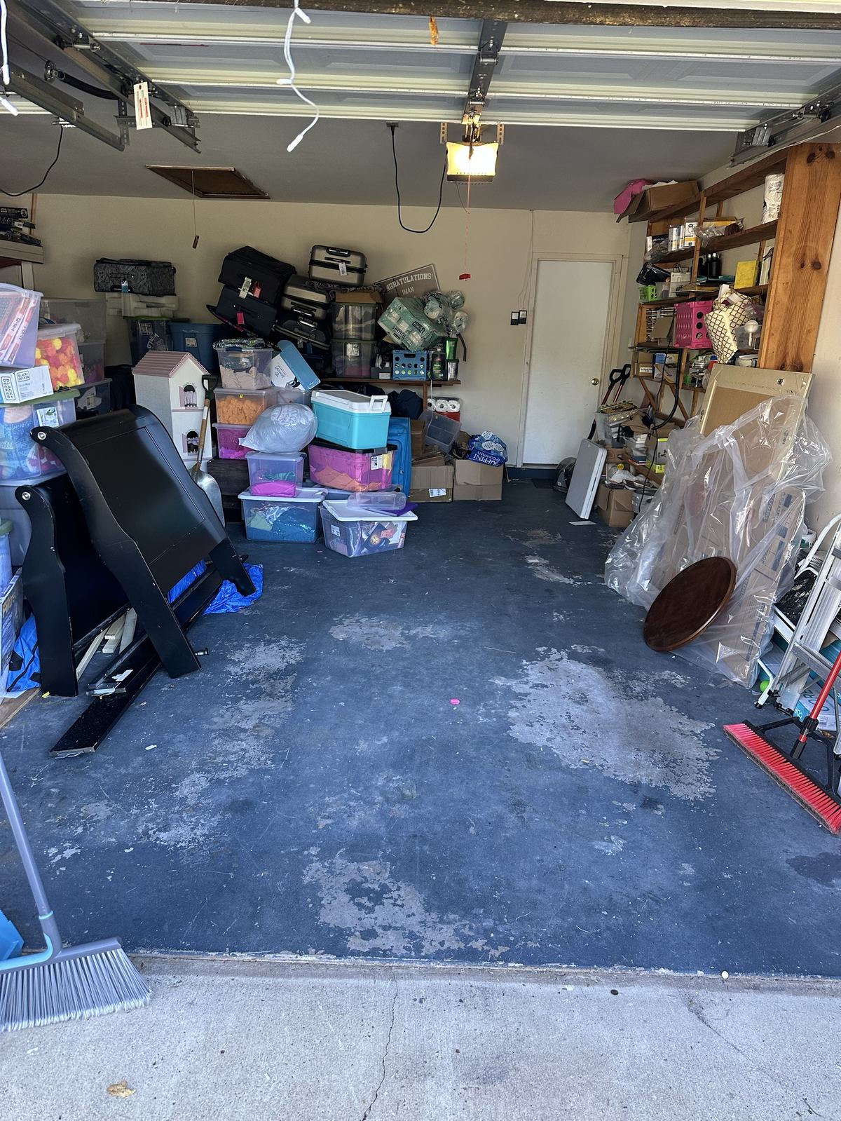Full garage with sleigh bed frame and storage bins before cleanout — Leesburg, VA