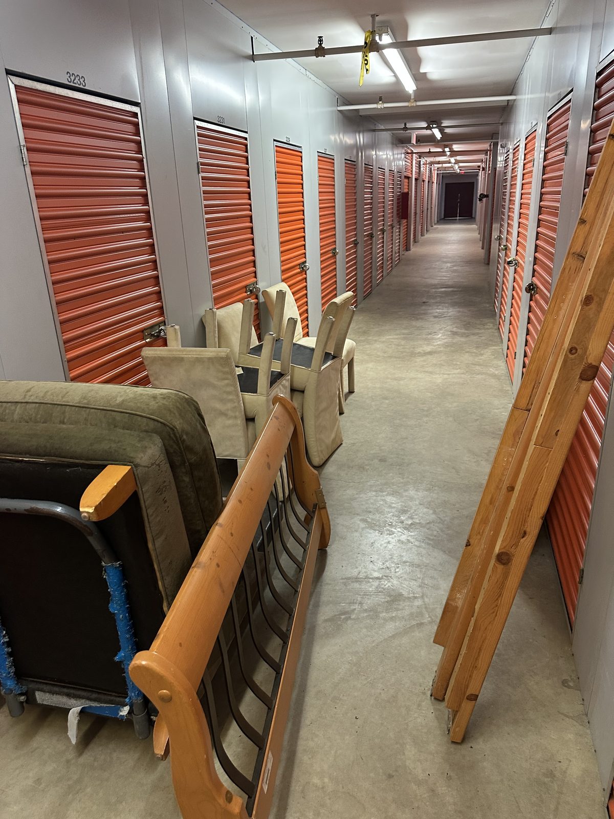 Storage unit hallway during cleanout — furniture staged for removal Leesburg VA
